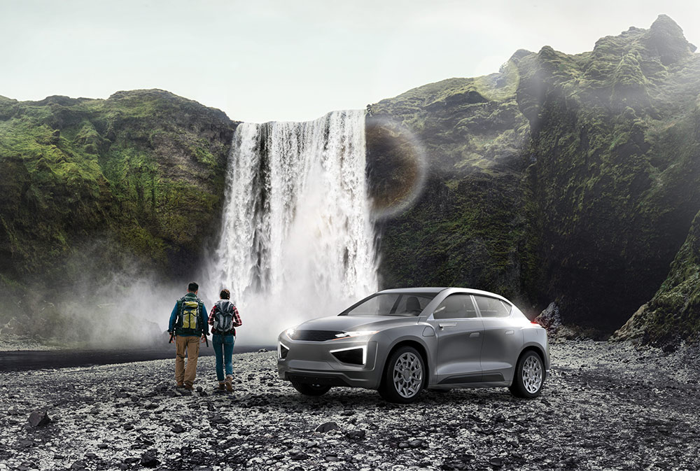 Two people standing beside a vehicle looking at a waterfall