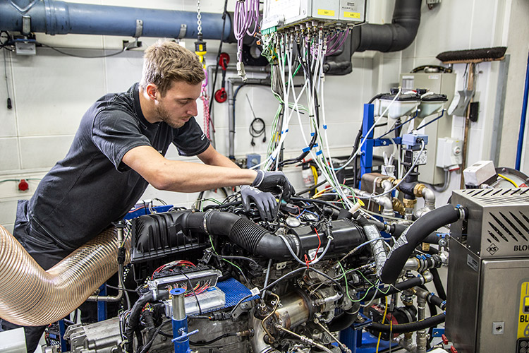 Technician calibrating and testing an engine in a laboratory setup