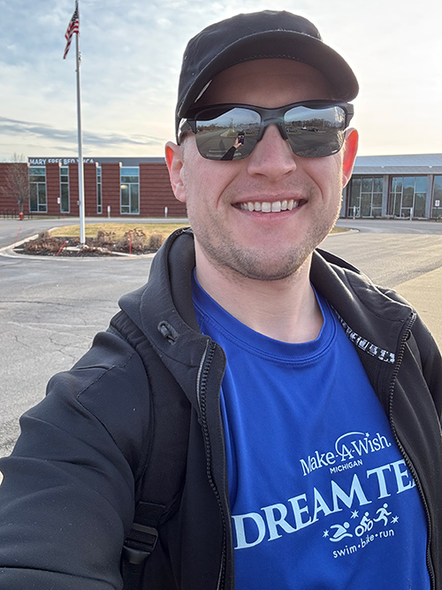 Luke taking a selfie outside wearing a Make-A-Wish Dream Team shirt