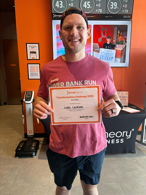 Luke holding a first-place Transformation Challenge 2025 certificate at a fitness center
