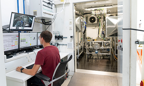 Rear view of grey vehicle taillights on with fog in background