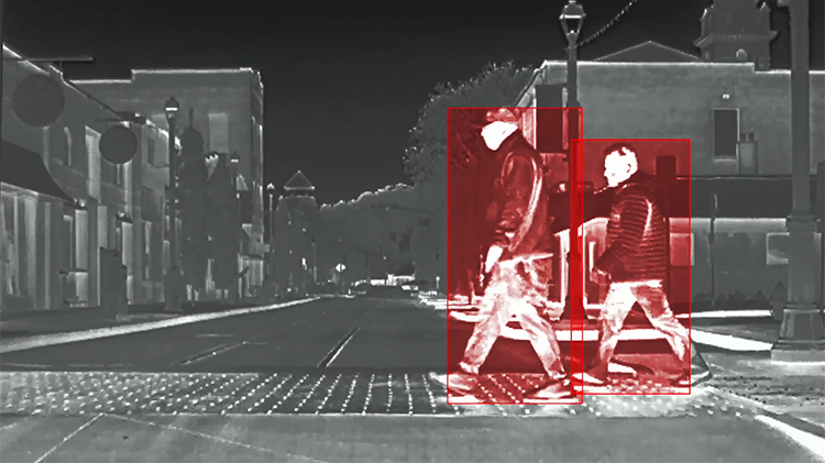 Thermal sensing detecting two people crossing the road at night