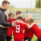 soccer players huddling with coach